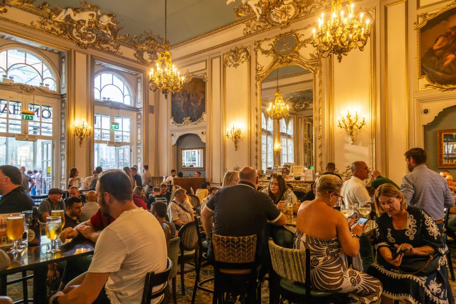 People socializing in a bar with ornate decorations.