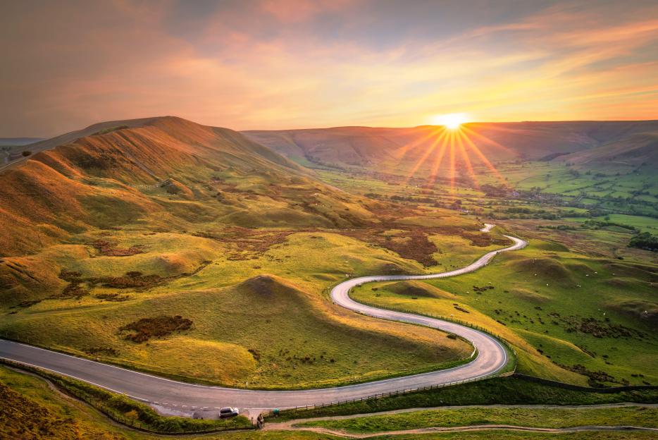 Winding road through hills at sunset.