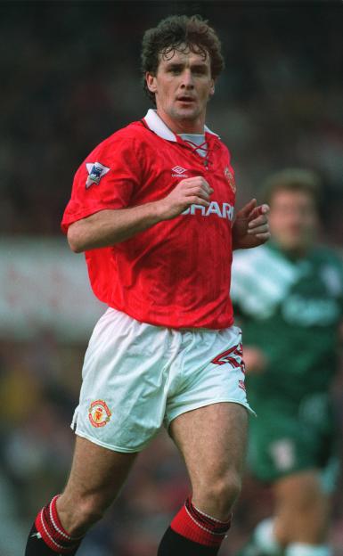 Mark Hughes of Manchester United in a red jersey and white shorts.