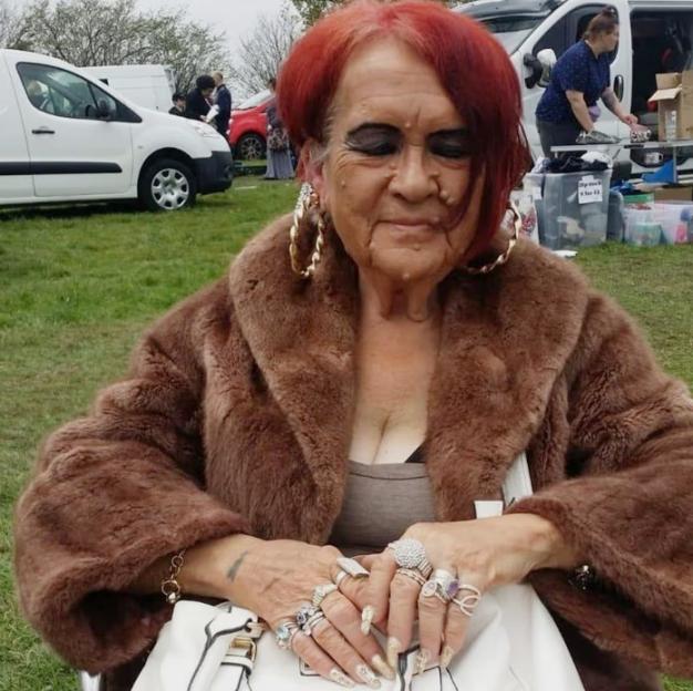 Carol Hall, wearing a fur coat, large earrings, and many rings.