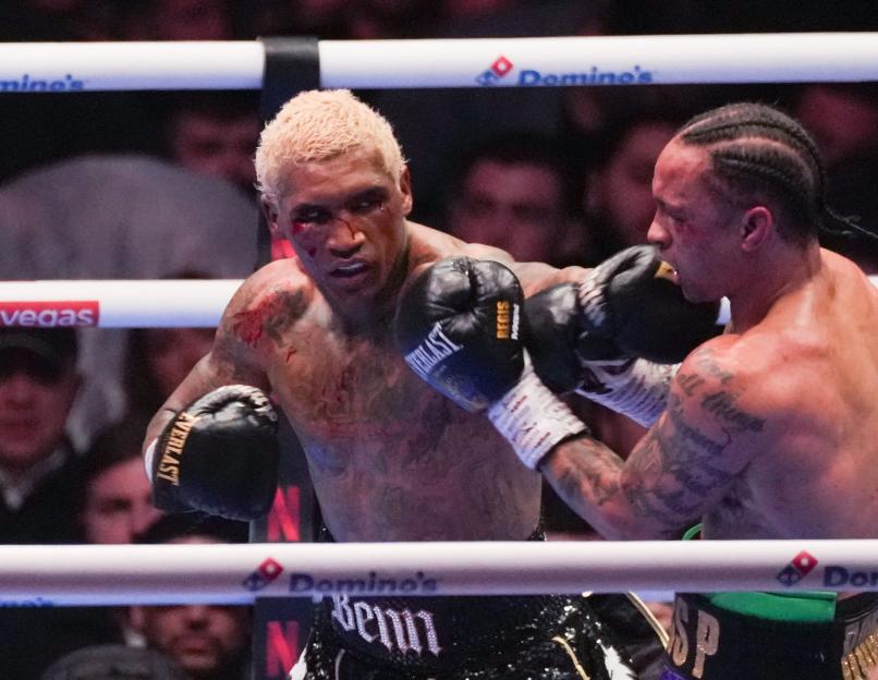 Boxer Conor Benn, bloodied, ducks a punch from Regis Prograis during a match.