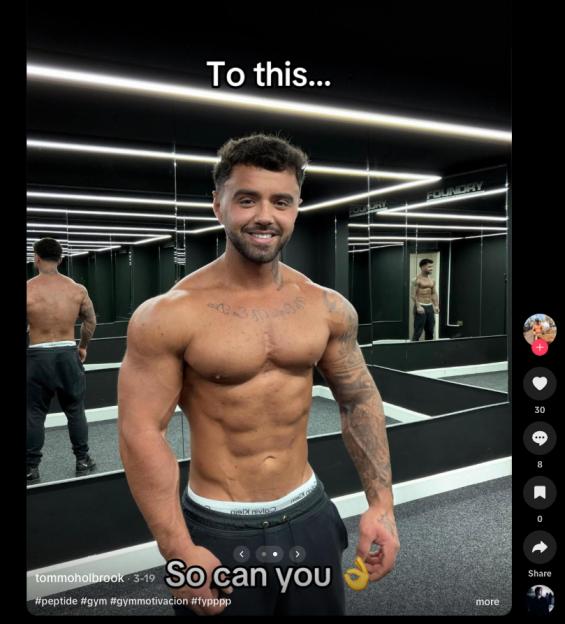 A muscular man with tattoos on his arms and chest, wearing black sweatpants, stands in a gym.