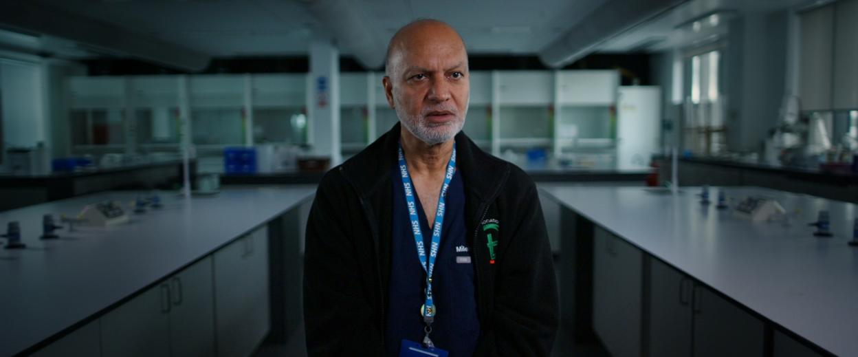 Dr. Latif Hussein, in a lab coat, looking at the camera.