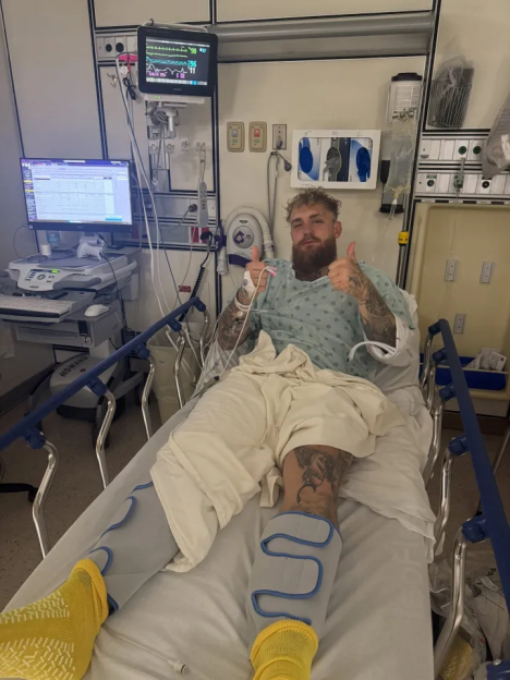 Jake Paul in a hospital bed with two thumbs up.