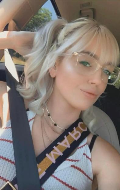 Katlyn Sale, a woman with blonde hair, wearing glasses and a seatbelt.