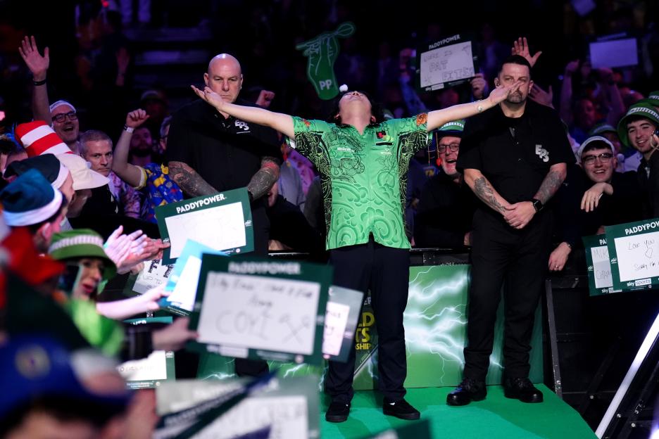 Motomu Sakai with his arms outstretched, facing the crowd at the Paddy Power World Darts Championship.