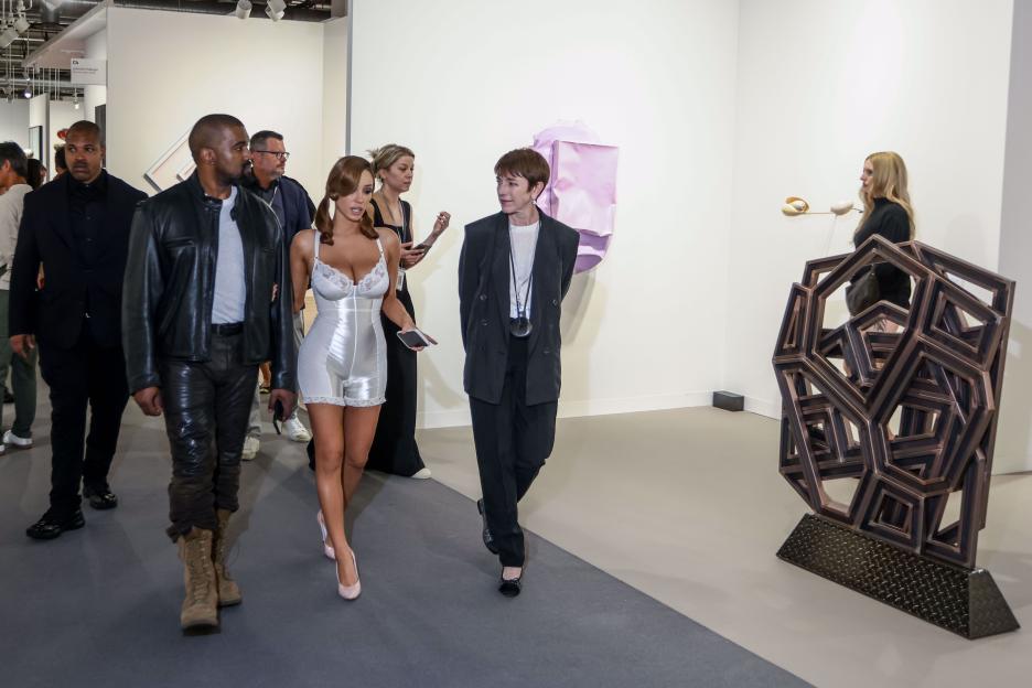 Bianca Censori in a white lingerie-like outfit with Kanye West at Art Basel.