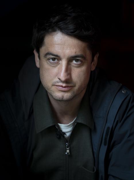 Investigative reporter Diamant Salihu, an expert on Swedish gangs, looks intently at the camera.