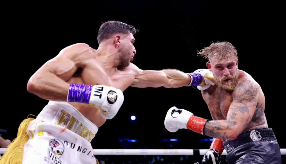 Tommy Fury landing a punch on Jake Paul during their boxing match.