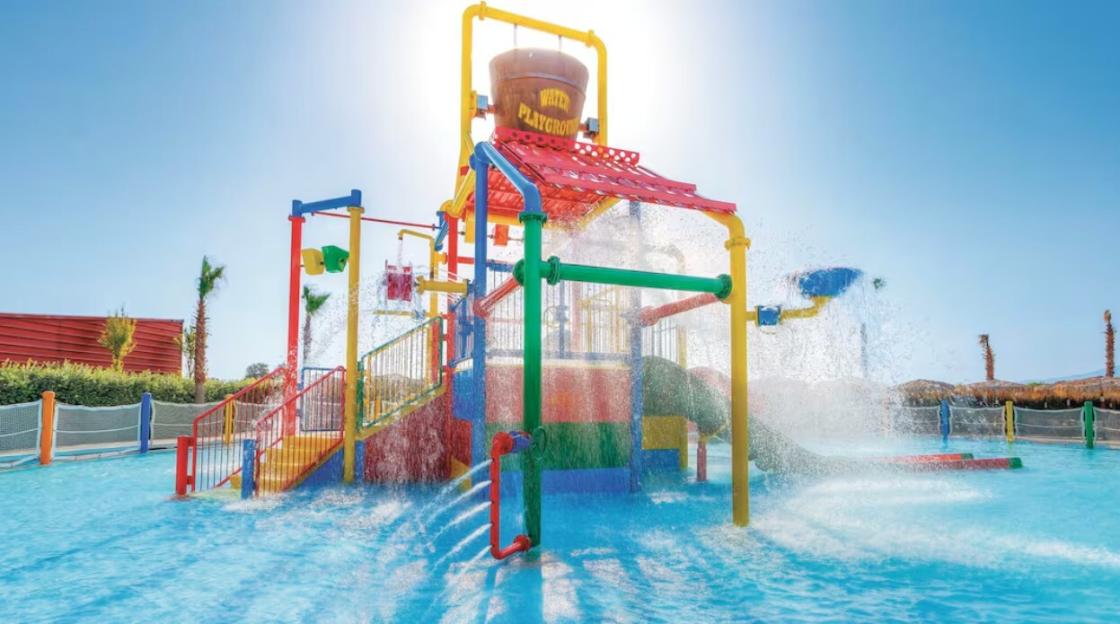 Water playground with slides and buckets splashing water into a pool.