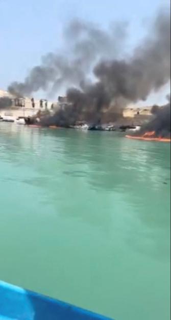 Smoke rises from boats on fire at a fishing pier in Banood, Bushehr Province
