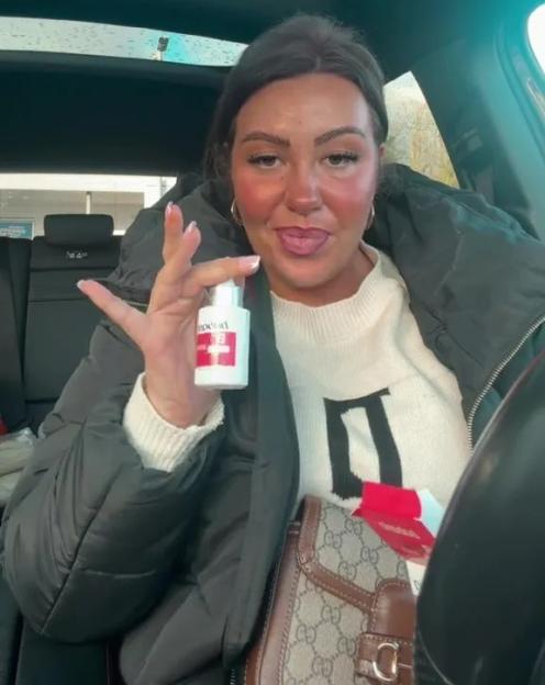 A woman in a car holds up a bottle of what is described as "Botox in a bottle."