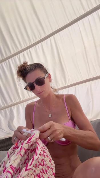 Luisa Zissman crocheting in a pink bikini under a white canopy.