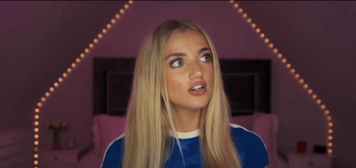 Princess Andre with a blue shirt and string lights in the background.