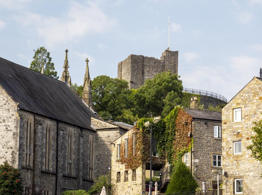 Clitheroe Castle keep rising above buildings and trees in Clitheroe, Lancashire, UK.