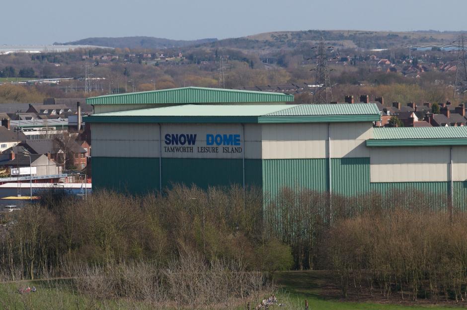 Exterior of SnowDome in Tamworth, Staffordshire, with hills and houses in the background.