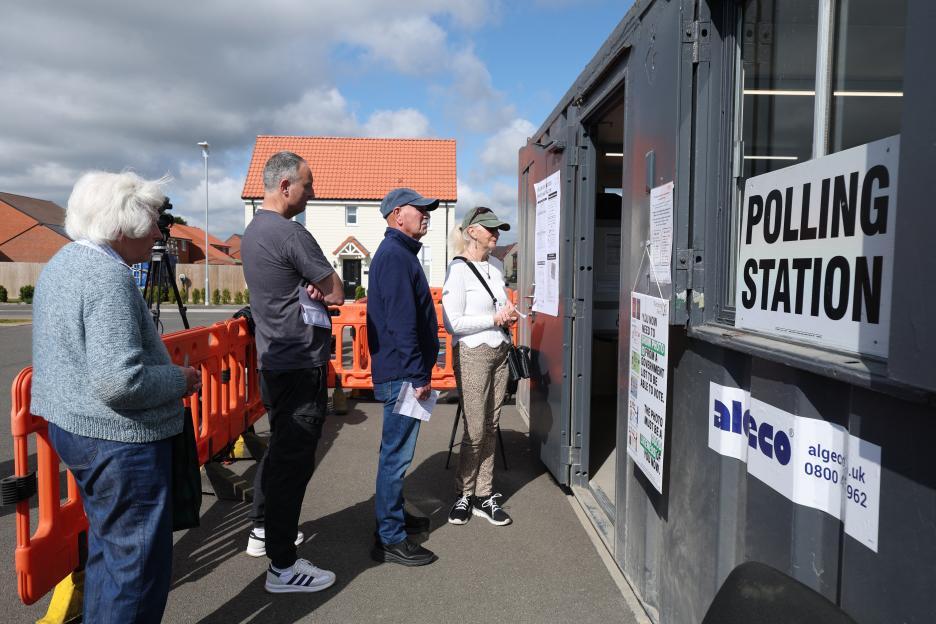 People line up to vote at a mobile polling station in Walton-on-the-Naze, eastern England.