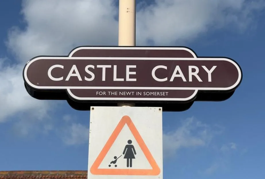 Castle Cary train station sign that reads, “Castle Cary - for the Newt in Somerset”.