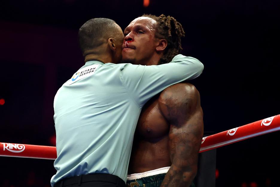 Referee Hector Afu stops the fight by embracing Anthony Yarde, whose nose is bleeding.