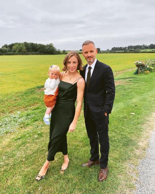 Jack Ryder with his partner and child in a field.
