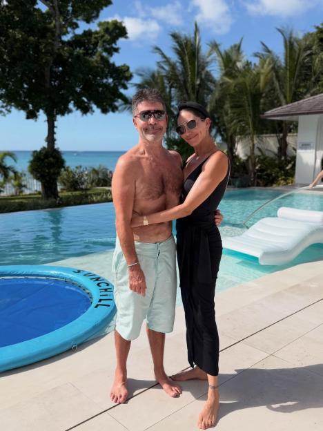 Simon Cowell and Lauren Silverman pose by a pool.