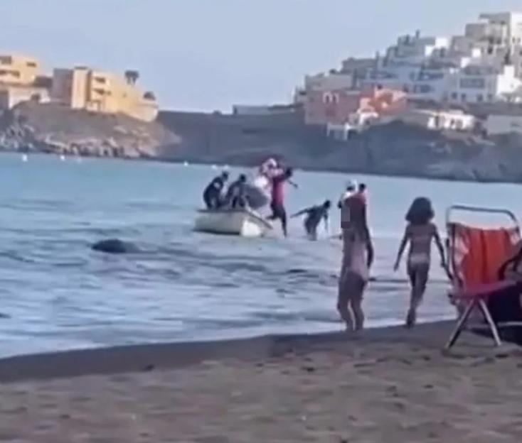Migrant 'Taxi Boat' Docks at Busy Spanish Beach, Shocking Tourists as Men Leap Off and Wade Ashore