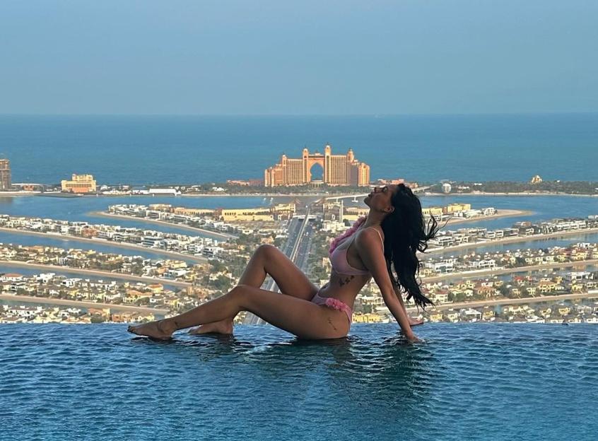 Pascha Myhill in an infinity pool overlooking Dubai's Palm Jumeirah.