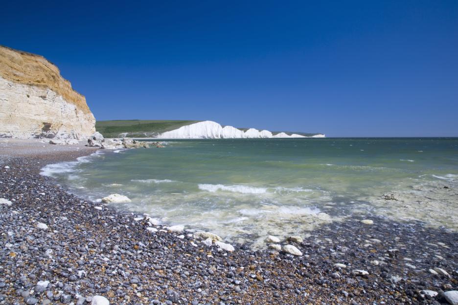 Pebble beach and white cliffs of Sussex, England.