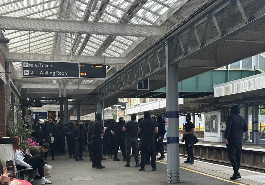 Protesters, some in balaclavas, at Dover Priory train station.