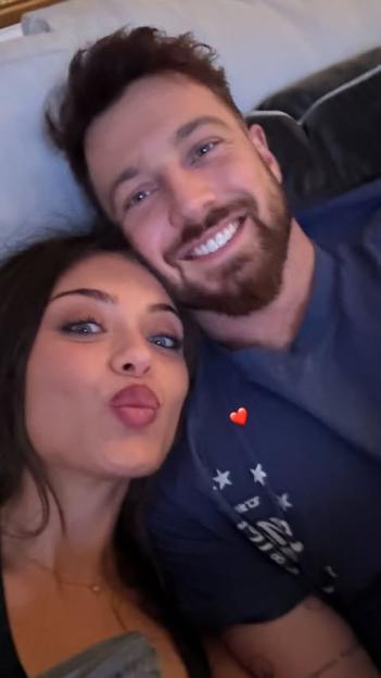 A man and a woman posing for a selfie, the woman pouting with pursed lips and the man smiling broadly.