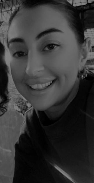 Black and white close-up of Sian Sanghera smiling.