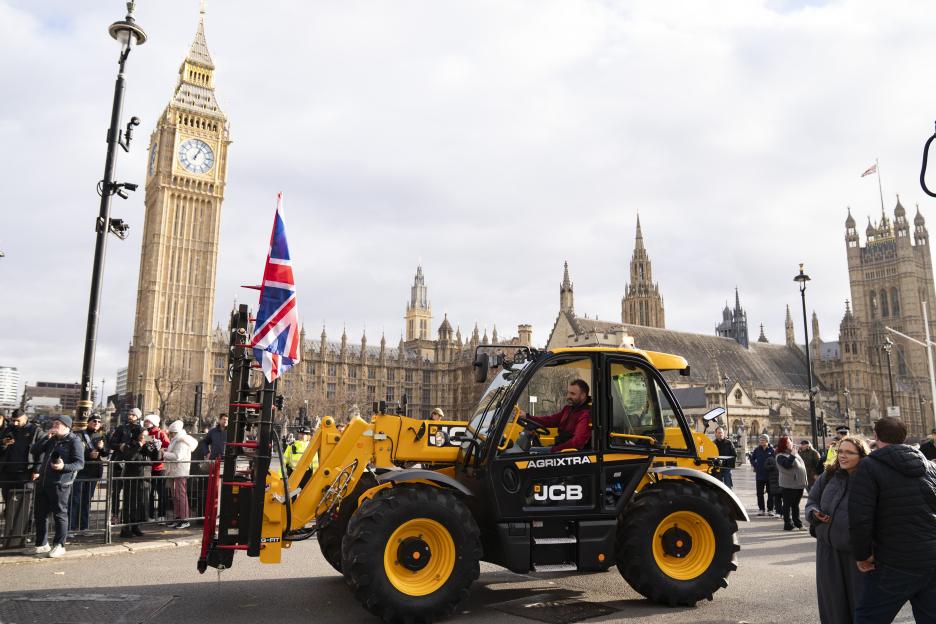 A farmer drives a yellow JCB tractor past Big Ben and the Houses of Parliament in Westminster, London, as part of a protest.