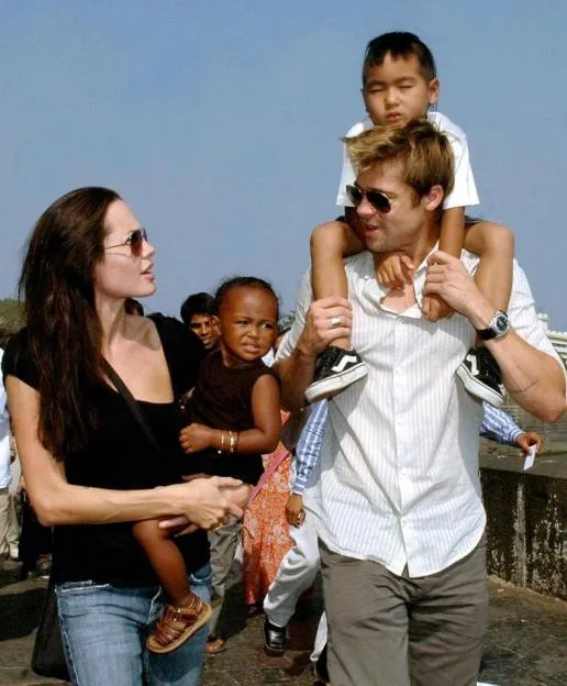Angelina Jolie holding daughter Zahara while Brad Pitt carries son Maddox on his shoulders during a stroll in Mumbai.