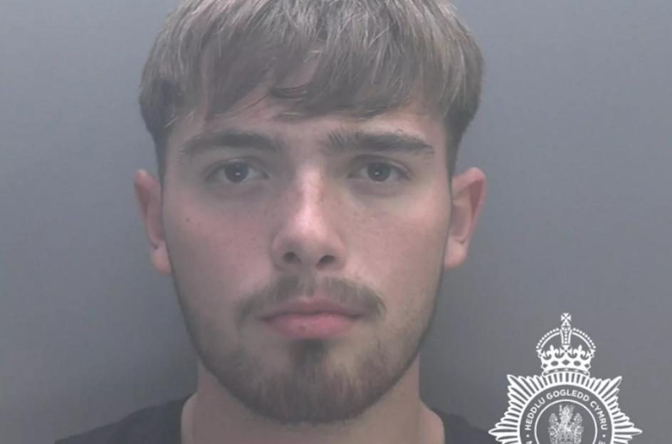 Mugshot of 19-year-old Thomas Baker with short brown hair and a beard, looking directly at the camera.
