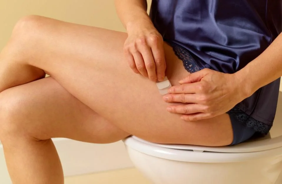 49 year old woman applying HRT patch to thigh