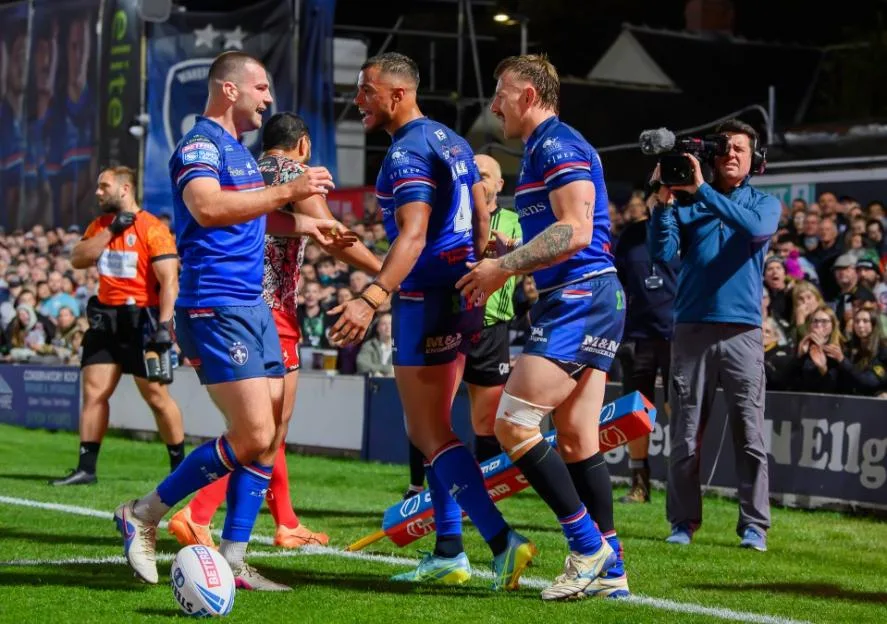 Wakefield Trinity rugby players celebrate on the field.