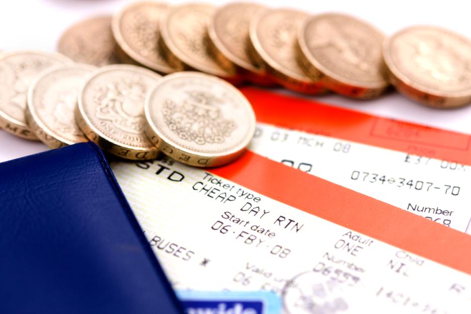 Train tickets and national rail railcard with pound coins in the background