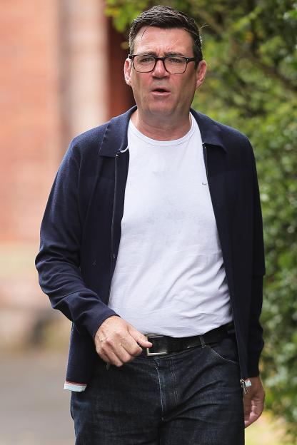Andy Burnham leaving his home, wearing a navy jacket and jeans.