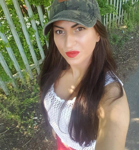 Sarah Egan, 36, wearing a camo hat and red lipstick.