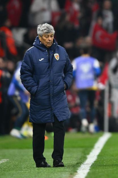 Coach Edward Iordănescu watches the game from the sideline.