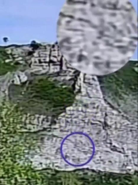 Blurred image of a body on a cliff after falling, circled in purple.