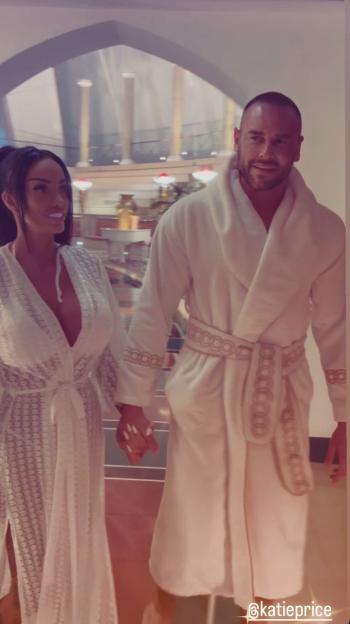 Katie Price and Lee Andrews holding hands while wearing robes.
