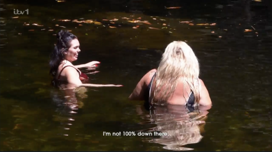 Two women partially submerged in murky water with text reading "I'm not 100% down there."