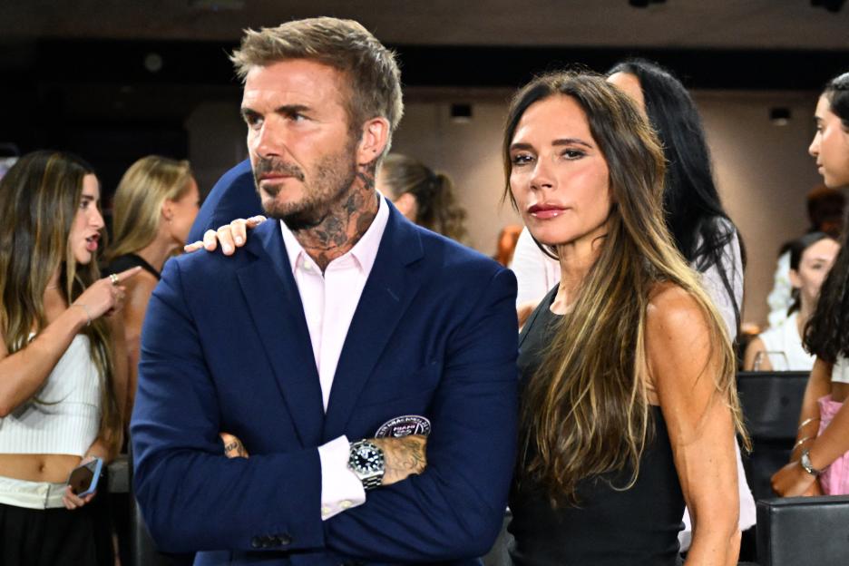 David and Victoria Beckham watching a football match.