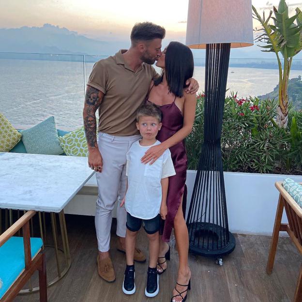 Jake Quickenden and Sophie Church kiss while their child stands between them.
