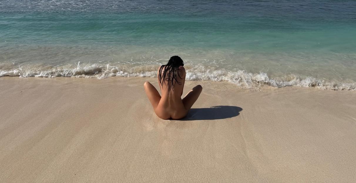 Kendall Jenner sitting naked on the beach.
