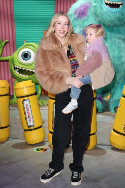 Katherine Ryan holds a child at the Mundo Pixar Experience VIP Launch.
