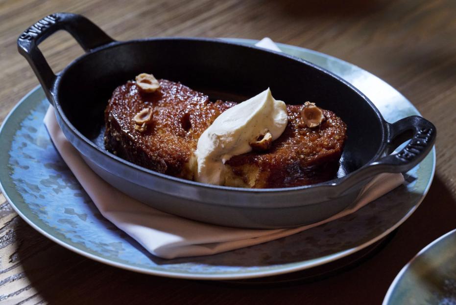 French toast with cream and hazelnuts in a cast iron dish.