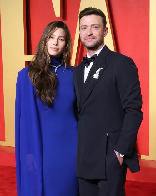 Jessica Biel in a royal blue cape gown and Justin Timberlake in a black tuxedo with a jeweled brooch.
