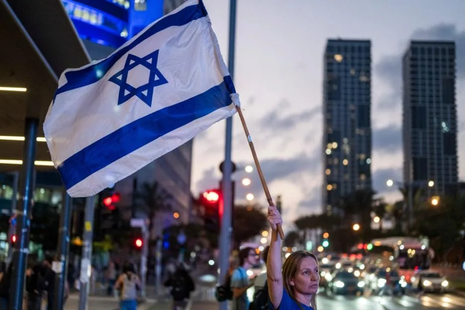 A supporter of The Democrats party waves an Israeli flag on a Tel Aviv street ahead of the legislative election.